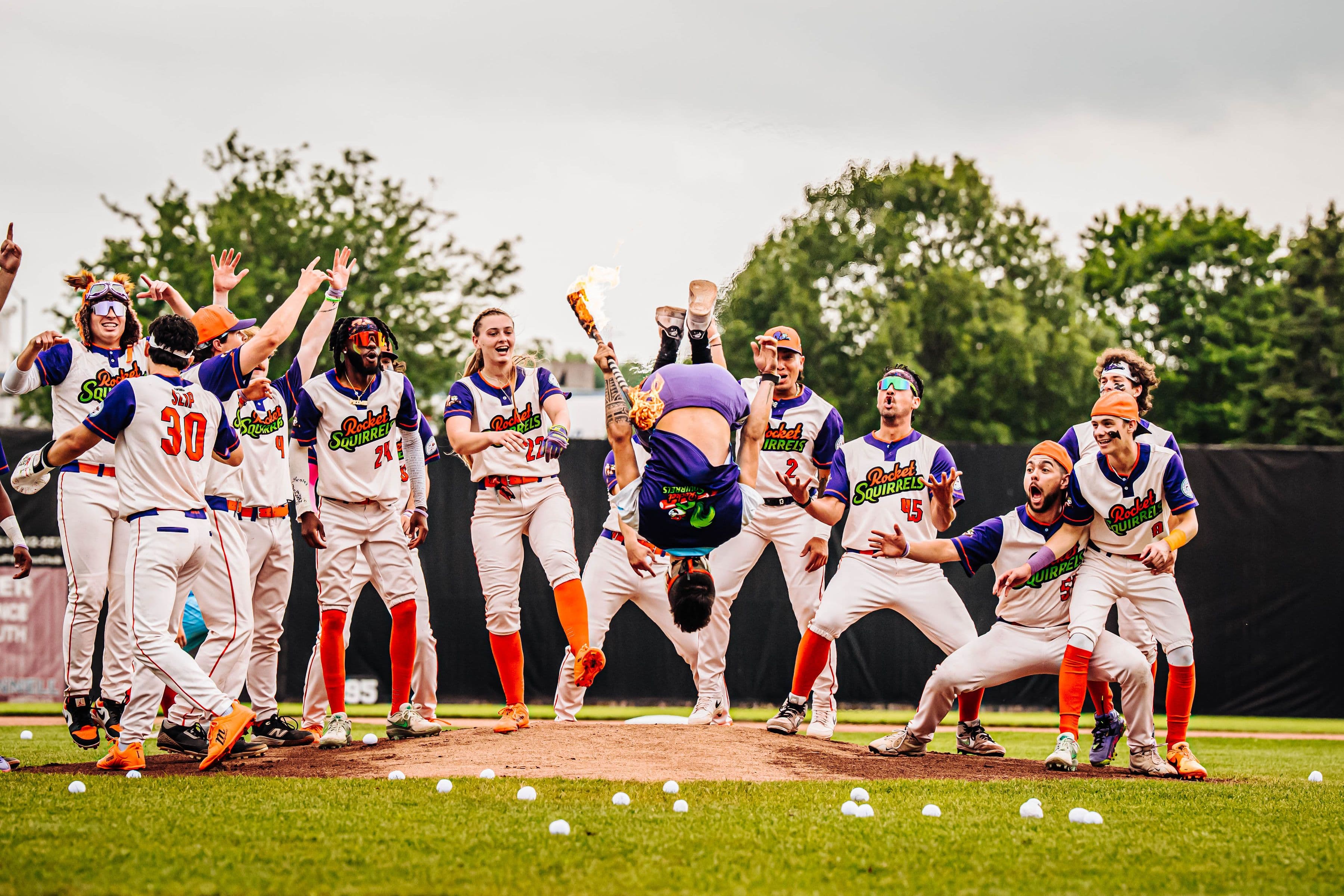 Players celebrate an acrobatic flip at home plate