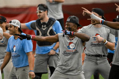 Teammates packed together with fists and arms thrown up, celebrating during camp